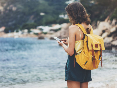 Jeune femme à l'étranger qui utilise son GSM et données mobiles à l'étranger en Europe